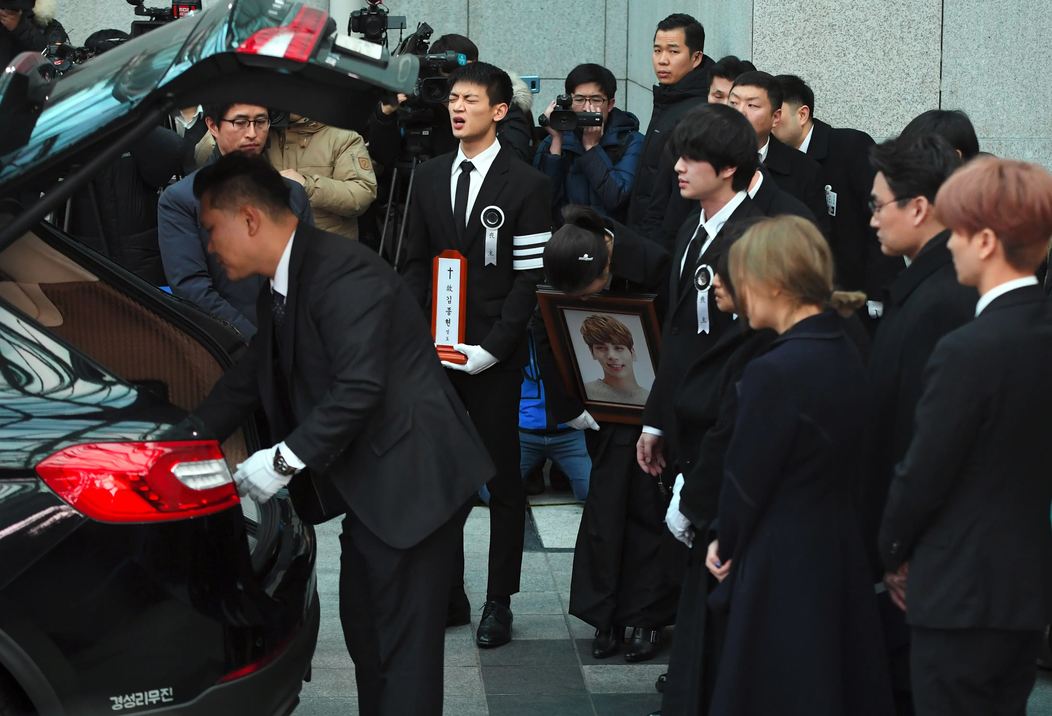 Raut kesedihan terlihat begitu jelas di wajah para personel SHINee ini. (JUNG Yeon-Je/AFP)
