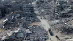 Foto udara memperlihatkan orang-orang berjalan melewati reruntuhan rumah di Rafah, Jalur Gaza Selatan pada 20 Januari 2025. (Foto oleh AFP)