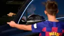 Seorang bocah saat menunggu Lionel Messi di lokasi latihan Barcelona, Senin (31/8/2020). Messi secara mengejutkan tidak datang untuk mengikuti tes swab Covid-19 yang dijadwalkan Barcelona. (AFP/Pau Barrena)