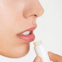 Seorang perempuan menggunakan produk lip balm untuk merawat bibirnya (Foto Dok: Freepik/rawpixel.com)