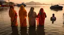 Umat Hindu memanjatkan doa kepada Dewa Matahari pada perayaan 'Chhath Puja' di tepi Sungai Brahmaputra di Guwahati pada Senin 27 Oktober 2025. (Biju BORO/AFP)