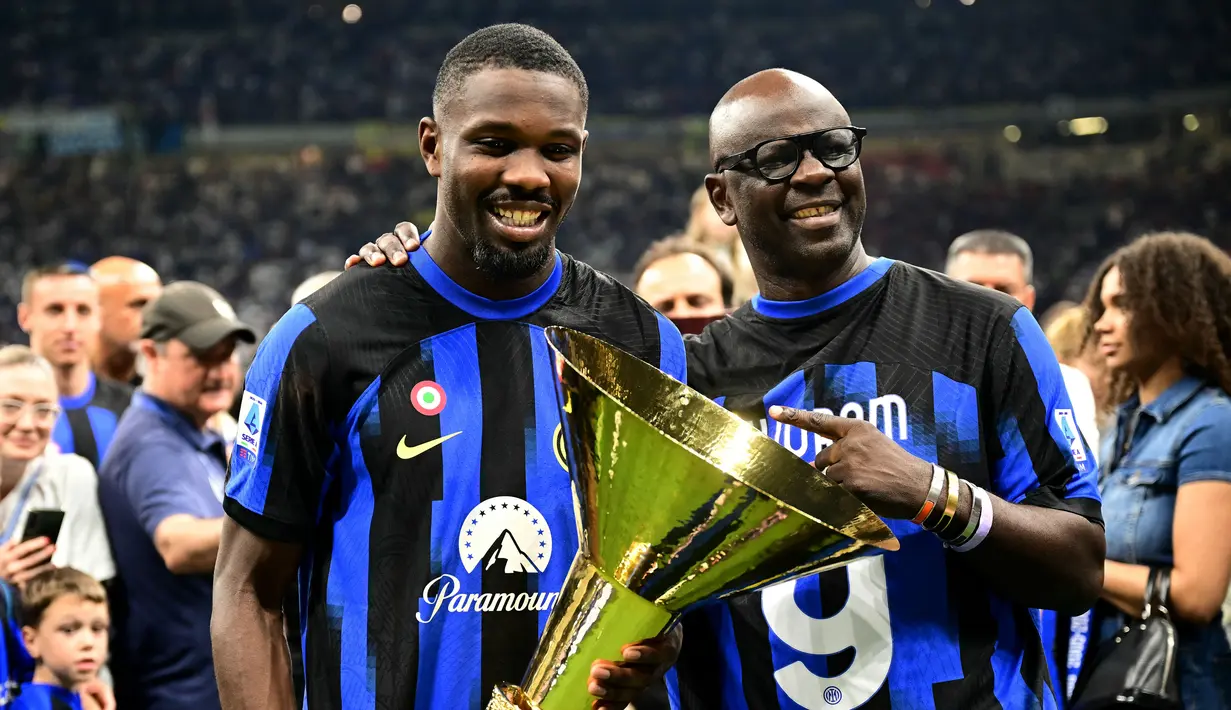 Pemain Inter Milan, Marcus Thuram, merayakan gelar juara Serie A bersama sang ayah yang juga seorang legenda Juventus yakni Lilian Thuram di Stadion Giuseppe Meazza, (19/5/2024). (AFP/Marco Bertorello)