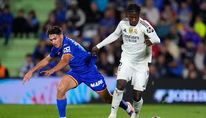 Pemain Getafe, Mario Martin (kiri), dan pemain Real Madrid, Eduardo Camavinga, berebut bola dalam pertandingan La Liga antara Getafe&nbsp;vs Real Madrid, 19 Oktober 2025. (AP Photo/Manu Fernandez)