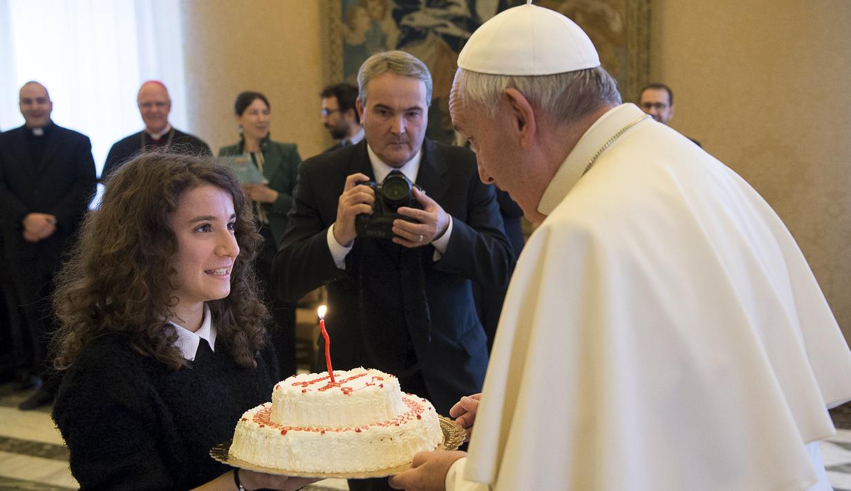 Paus Fransiskus saat menerima sebuah kue ulang tahun dari remaja anggota Italian Catholic Action saat ulang tahun ke-79 tahun di Vatikan, Kamis (17/12/2015). (REUTERS/Osservatore Romano)