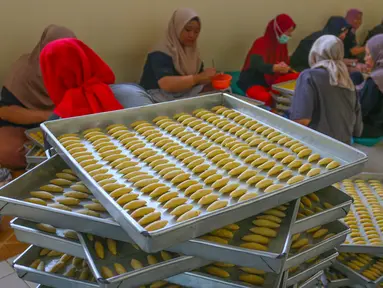 Pekerja menyelesaikan pembuatan kue kering lebaran di industri rumahan Risa Resa Cookies, Ciganjur, Jakarta, Senin (18/03/2023). (merdeka.com/Arie Basuki)