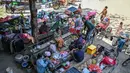 Sementara itu, puluhan ribu orang telah meninggalkan rumah mereka di dekat perbatasan untuk mencari tempat penampungan yang aman. Tampak dalam foto, warga berkumpul di luar sebuah kuil setelah dievakuasi menyusul bentrokan di sepanjang perbatasan Kamboja-Thailand, di provinsi Siem Reap pada Selasa 9 Desember 2025. (TANG CHHIN SOTHY/AFP)