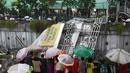 Warga menonton Jembatan Penyeberangan Orang (JPO) yang roboh akibat hujan deras dan angin kencang di Jalan Raya Pasar Minggu, Jakarta Selatan, Sabtu (24/09). Petugas masih memotong bagian JPO tersebut. (Liputan6.com/Immanuel Antonius)