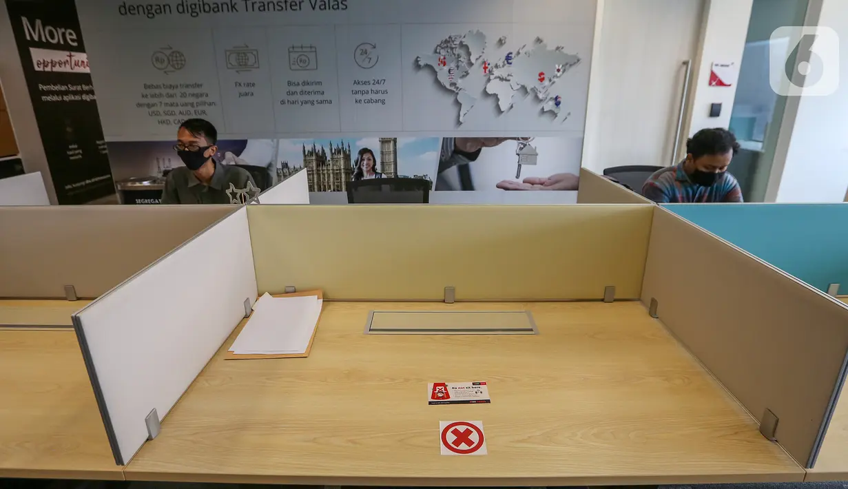 Sejumlah karyawan saat bekerja mengikuti aturan physical distancing di kantor DBS Tower, Jakarta, Selasa (30/6/2020). Bank DBS Indonesia menerapkan protokol kesehatan, penyesuaian operasional dan penataan ulang struktur penempatan karyawan di area kantor. (Liputan6.com/Fery Pradolo)