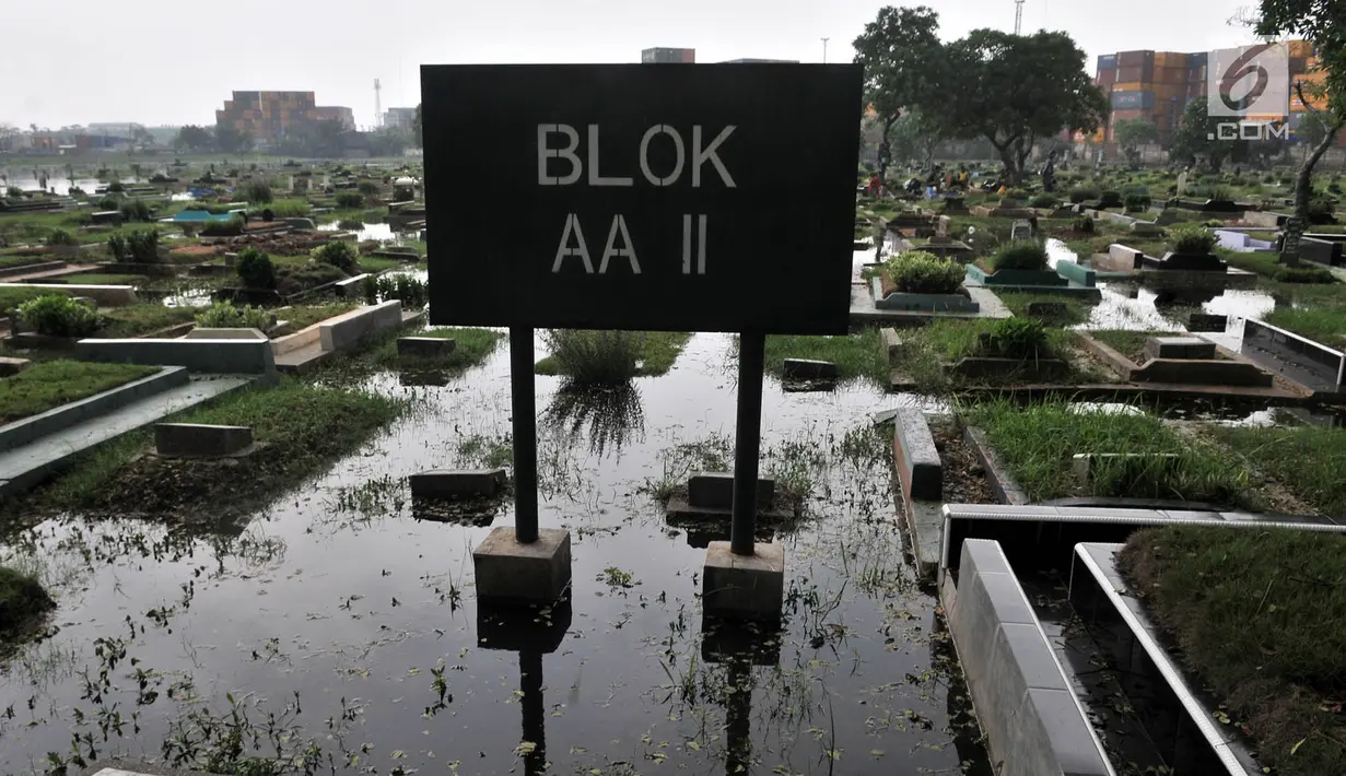 Kondisi ratusan makam yang terendam banjir di TPU Semper, Jakarta, Selasa (4/12). TPU Semper menjadi langganan banjir saat musim penghujan akibat rendahnya permukaan tanah dengan ketinggian air sepinggang orang dewasa. (Merdeka.com/Iqbal S. Nugroho)