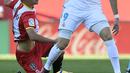 Pemain Girona, Pere Pons (kiri) berusaha menahan laju pemain Real Madrid, Karim Benzema pada lanjutan La Liga Santander di Municipal de Montilivi stadium, Girona , (29/10/2017). Madrid kalah 1-2. (AFP/Josep Lago)