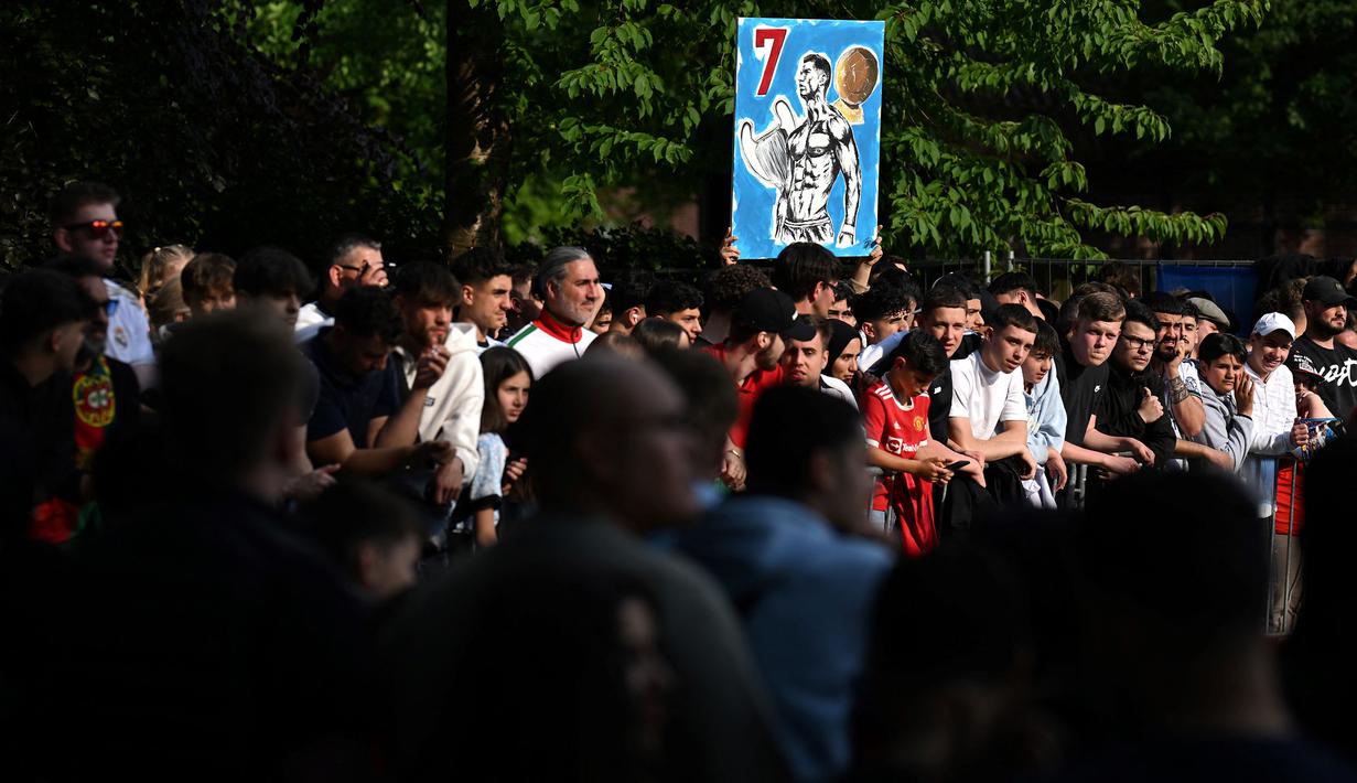 Seorang fans membawa poster Cristiano Ronaldo saat menyambut kedatangan Timnas Portugal di hotel tempat mereka menginap jelang Euro 2024 di Harsewinkel, Jerman, Rabu (13/06/2024) waktu setempat. (AFP/Patricia De Melo Moreira)