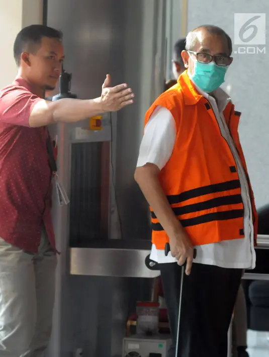 Bupati Bandung Barat Abubakar mengenakan tongkat dikawal petugas untuk menjalani pemeriksaan lanjutan di gedung KPK, Jakarta, Selasa (8/5). (Merdeka.com/Dwi Narwoko)