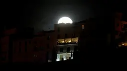 Supermoon yang muncul diatas sebuah penginapan Ronda, Spanyol, Senin (17/10). Supermoon merupakan fenomena di kala bulan terlihat bulat secara penuh dengan kondisi lebih besar dan paling terang dari biasanya. (Reuters/Jon Nazca)