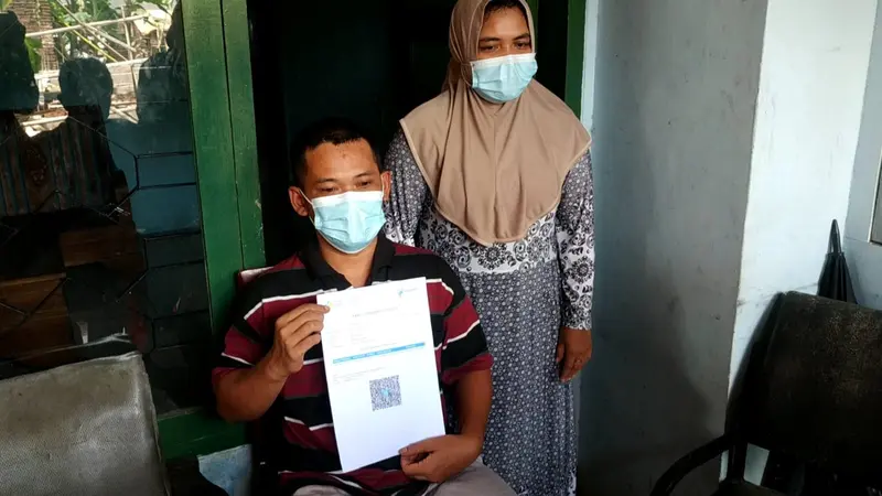 Joko Santoso menunjukkan sertifikat vaksin miliknya.  (Zainul Arifin/Liputan6.com)