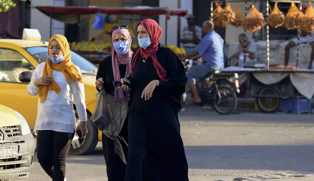 Perempuan Tunisa mengenakan masker untuk melindungi diri dari virus Corona terlihat di sebuah pasar saat kasus baru infeksi melonjak, di kota Gabes, Rabu (27/8/2020). Tunisia pada 25 Agustus 2020 melaporkan peningkatan tertinggi kasus baru Covid-19 dibandingkan minggu sebelumnya. (FETHI BELAID/AFP)