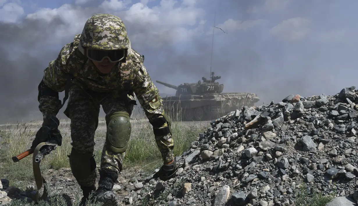 Seorang tentara Kyrgyzstan berlari ke tempat perlindungan saat latihan militer bersama di tempat latihan Edelweiss, Kyrgyzstan, Kamis (9/9/2021). Latihan ini diikuti negara-negara Organisasi Perjanjian Keamanan Kolektif atau Collective Security Treaty Organization. (AP Photo/Vladimir Voronin)