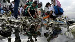 Relawan mengempulkan sampah yang menumpuk di Manila Bay pada (19/9/2015). Kegiatan membersihkan pantai ini untuk memperingati International Coastal Cleanup Day atau Hari membersihkan pantai internasional. (AFP PHOTO/NOEL CELIS)