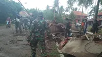 Anggota TNI membersihkan puing sisa rumah yang dihantam tsunami Selat Sunda (Liputan6.com/Yandhi)