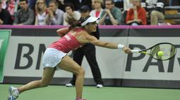 Martina Hingis berusaha mengembalikan bola pukulan Urszula Radwanska. (AFP PHOTO/PIOTR HAWALEJ)