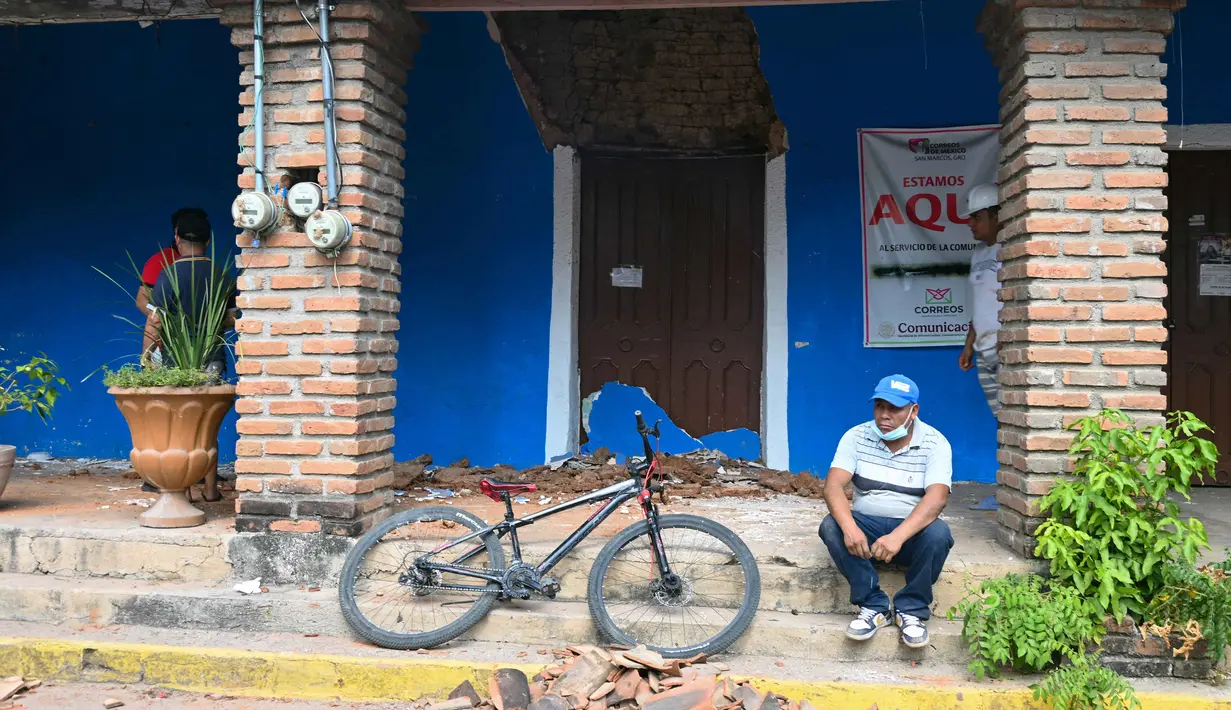 Gempa dilaporkan terasa hingga sekitar 400 kilometer (km) ke arah utara Mexico City. Tampak dalam foto, seorang pria duduk di depan rumah yang rusak setelah guncangan gempa bumi berkekuatan 6,5 magnitudo di komunitas San Marcos, negara bagian Guerrero, Meksiko pada Jumat 2 Januari 2026. (Francisco ROBLES/AFP)