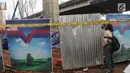 Seorang wanita mengambil gambar tiang girder Tol Bekasi-Cawang-Kampung Melayu (Becakayu) yang ambruk di Kebon Nanas, Jakarta Timur, Selasa (20/2). Peristiwa terjadi saat para pekerja melakukan pengecoran pada penyangga tiang. (Liputan6.com/Arya Manggala)