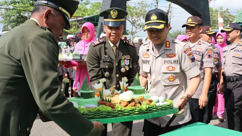 Kapolres Kebumen AKBP Rudy Kurniawan menyerahkan kue ulang tahun kepada jajaran Kodim 0709 Kebumen pada HUT ke-74 TNI. (Foto: Liputan6.com/Polres KebumenMuhamad Ridlo)