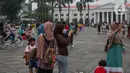 Wisatawan menikmati suasana Kota Tua, Jakarta, Selasa (26/12/2023). (Liputan6.com/Faizal Fanani)