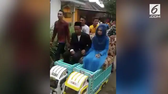 Pasangan pengantin asal Malang, Jawa Timur, diarak menggunakan miniatur truk yang terbuat dari kayu.