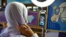 Seorang siswa menjalani perekaman gambar saat tiba di Sekolah Pimarnvit, Provinsi Narathiwat, Thailand, 20 Mei 2022. Thailand melanjutkan sekolah tatap muka secara nasional untuk tahun ajaran baru setelah bertahun-tahun terganggu karena pandemi COVID-19. (Madaree TOHLALA/AFP)