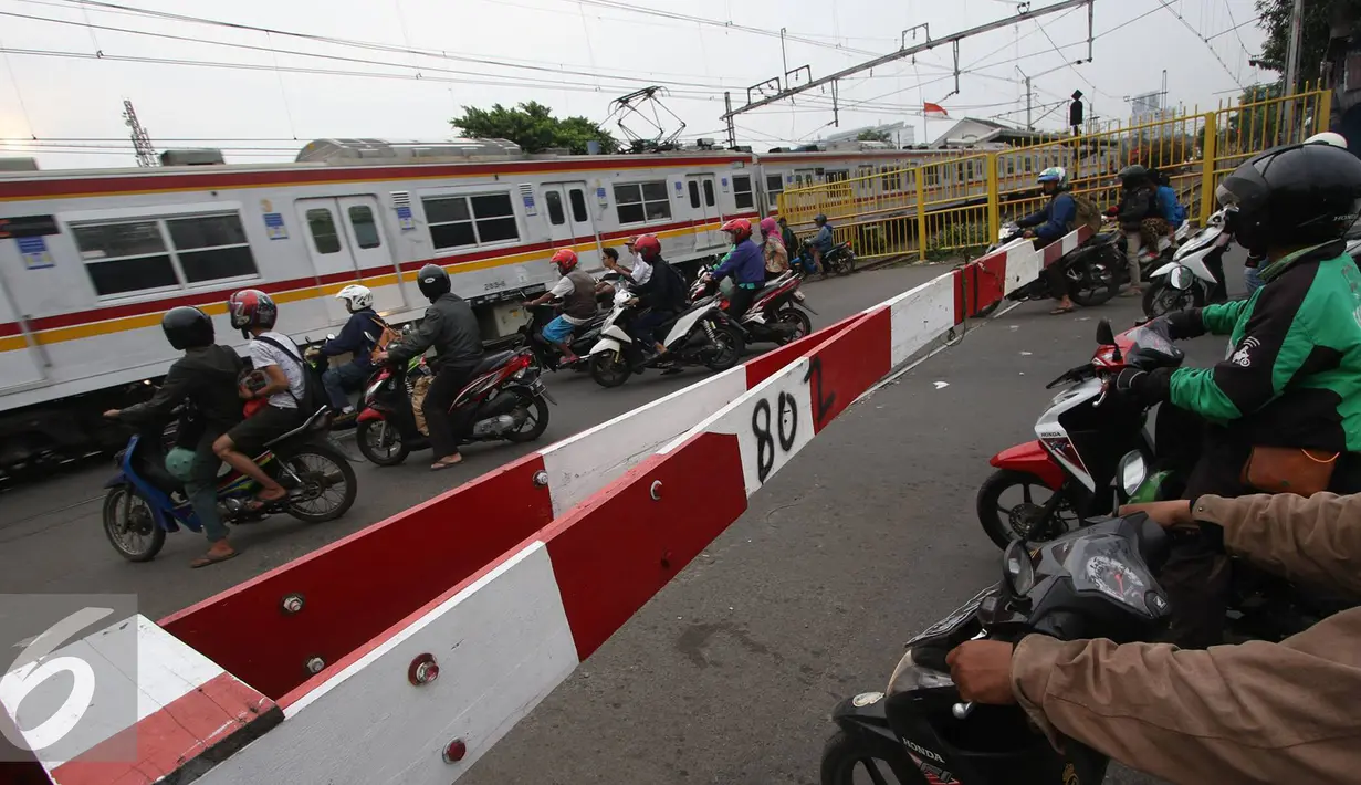 Salah satu bukti rendahnya tingkat kesadaran berlalu lintas yang baik di palang pintu perlintasan kereta di Kemayoran, Jakarta, Kamis (6/10). Pemotor menerobos palang pintu tanpa rasa takut tersambar kereta api lewat. (Liputan6.com/Immanuel Antonius)