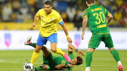 Pemain Al Nassr, Cristiano Ronaldo (kiri) berebut bola dengan pemian Al Shorta, Alaa Al-Azzawi pada laga semifinal Liga Champions Arab 2023 di Prince Sultan bin Abdul Aziz Stadium, Abha, 9 Agustus 2023. Al Nassr sukses melaju ke babak final setelah menang dengan skor 1-0. (AFP/Abdullah Mahdi)