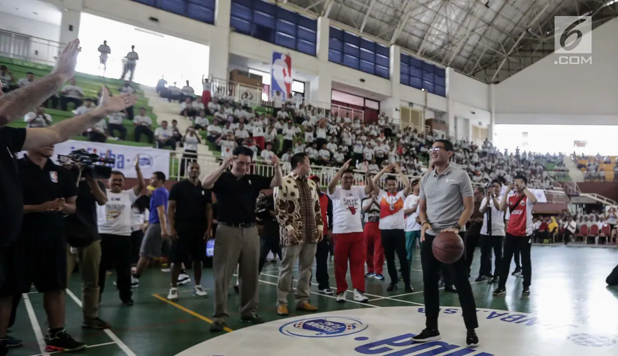 Wagub DKI Jakarta Sandiaga Uno bersiap menembakan bola usai membuka pelatihan pendidikan Basket di Gor Ciracas, Jakarta, Rabu (24/1). Pendidikan basket ini diberikan kepada lebih dari 5.000 guru olahraga dari 3.000 sekolah. (Liputan6.com/Faizal Fanani)