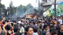 Sejumlah warga berkumpul melihat kecelakaan pesawat Hercules C-130 yang jatuh di kawasan perumahan di Medan, Selasa (30/6/2015). Hercules C-130 milik TNI AU jatuh tidak lama setelah lepas landas. (AFP PHOTO/Muhammad Zulfan Dalimunthe)