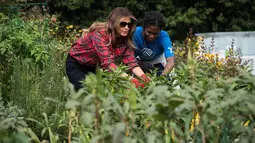 Ibu Negara AS, Melania Trump berkebun bersama anak-anak dari Boys & Girls Club di Kitchen Garden Gedung Putih, Jumat (22/9). Istri Presiden Donald Trump itu juga mengenakan sarung tangan dengan kacamata hitam Dolce & Gabbana. (NICHOLAS KAMM/AFP)
