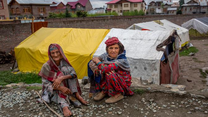 Gowri Khan dan Khatija, perempuan pengembara Kashmir Bakarwal duduk di luar kamp sementara di pinggiran Srinagar, India, 31 Agustus 2020. Suku Bakarwals adalah kaum penggembala nomaden di Jammu Kashmir, yang berpindah-pindah mencari padang rumput yang baik untuk ternak mereka. (AP Photo/Dar Yasin)