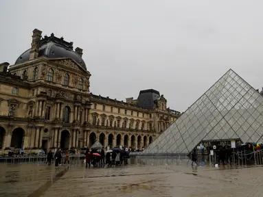Orang-orang mengantre di depan Louvre Pyramide di Paris pada Minggu (1/3/2020). Louvre, museum yang paling banyak dikunjungi di dunia, ditutup sementara untuk pengunjung setelah para staf mengutarakan kecemasan dan ketakutannya tertular virus corona tipe baru, Covid-19. (Thomas SAMSON/AFP)