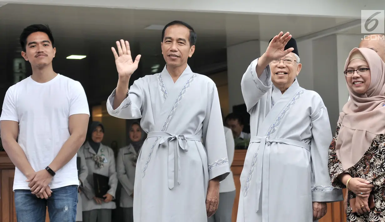 Bakal calon presiden dan wakil presiden Joko Widodo atau Jokowi (dua kiri) dan KH Ma'ruf Amin (dua kanan) melambaikan tangan sebelum tes kesehatan di RSPAD Gatot Subroto, Jakarta, Minggu (12/8). Keduanya mengenakan piyama. (Merdeka.com/Iqbal Nugroho)