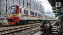 Rangkaian KRL melintasi permukiman liar Pela-Pela yang bersebelahan dengan Jakarta International Stadium (JIS), Kelurahan Papanggo, Tanjung Priok, Jakarta Utara, Selasa (22/2/2022). Warga berharap Pemprov DKI mendirikan tempat tinggal pengganti dan uang kompensasi. (merdeka.com/Iqbal S. Nugroho)