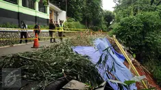 Pekerja memasang garis pembatas di jalan Gardu, Jagakarsa yang mengalami longsor pada Jumat (12/2) lalu, Jakarta, Sabtu (13/2/2016). Longsor terjadi akibat guyuran hujan deras dan tidak ada korban dalam peristiwa ini. (Liputan6.com/Helmi Fithriansyah)