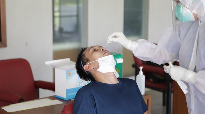 Atlet bulu tangkis ganda putra Indonesia Mohammad Ahsan menjalani tes PCR di Jakarta jelang keberangkatan ke Olimpiade Tokyo 2020. (foto: PBSI)