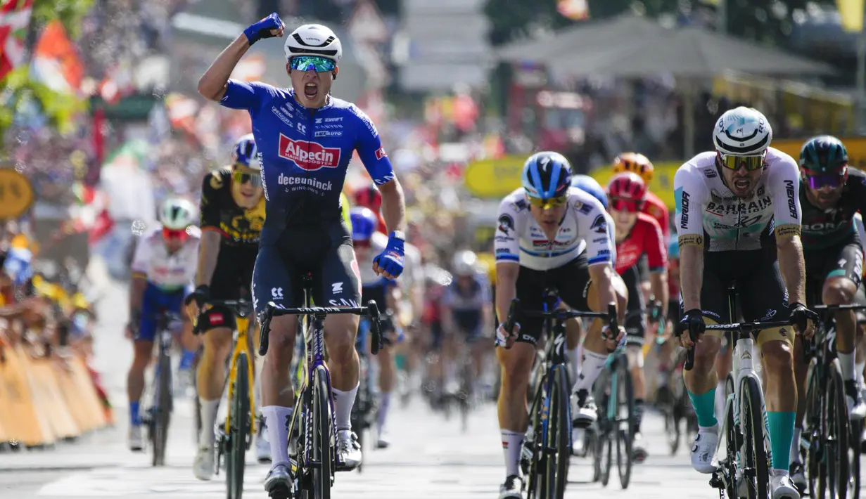 <p>Jasper Philipsen melakukan selebrasi saat melewati garis finis di depan pebalap Jerman Phil Bauhaus yang menempati posisi kedua (kanan), untuk memenangkan etape ketiga balap sepeda Tour de France di Bayonne, Prancis, Senin (3/7/2023). (AP Photo/Daniel Cole)</p>