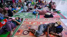 BPBD Pidie Jaya juga mencatat ada sekitar 1.247 rumah terendam, dan 67 lainnya rusak berat akibat longsor. Tampak dalam foto, warga desa terdampak banjir beristirahat di tempat pengungsian setelah banjir bandang melanda Meureudu, Kabupaten Pidie Jaya, Provinsi Aceh, pada 29 November 2025. (CHAIDEER MAHYUDDIN/AFP)