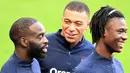 Penyerang Prancis, Kylian Mbappe, berbincang dengan Jonathan Ikone dan Eduardo Camavinga, saat latihan jelang laga UEFA Nations League di Paris, Senin (7/9/2020). Pemain PSG itu akan absen melawan Kroasia karena dinyatakan positif terjangkit COVID-19. (AFP/Franck Fife)