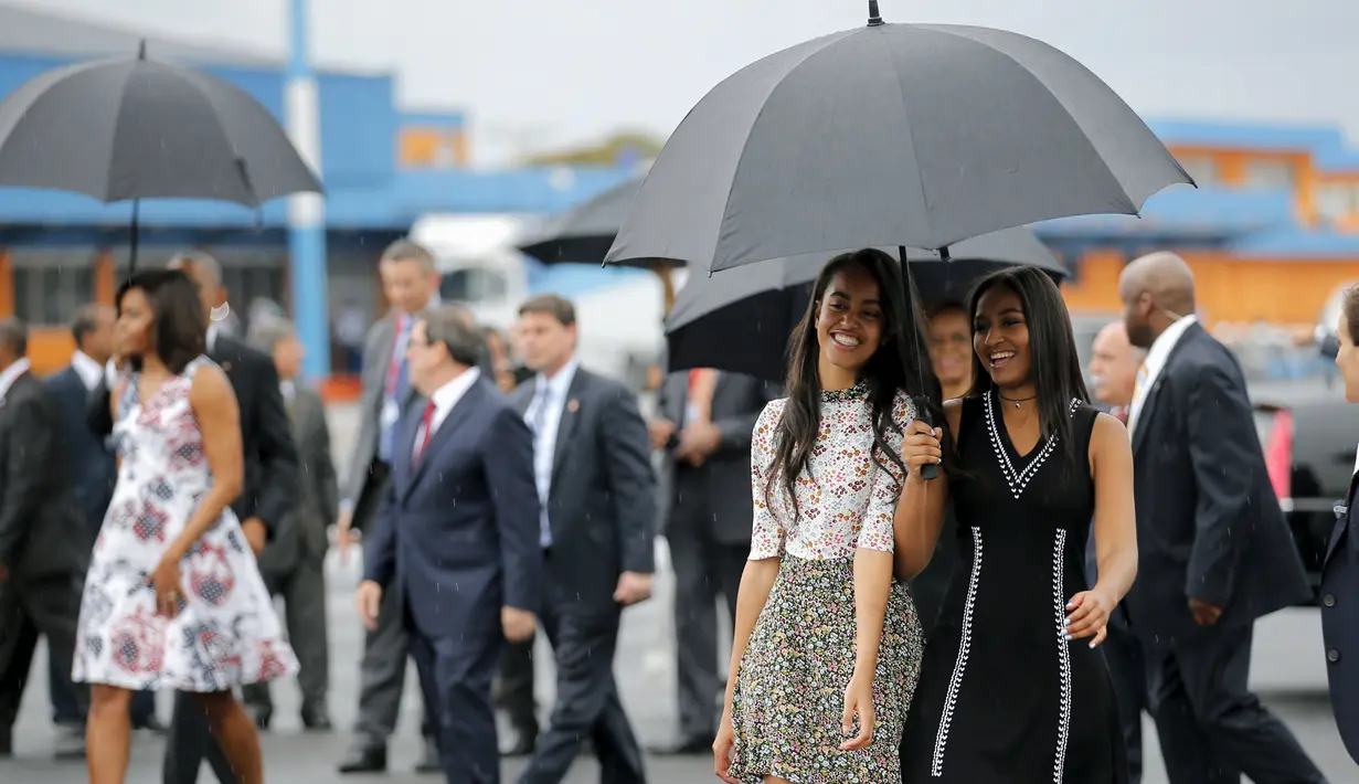 Putri Presiden Barack Obama, Sasha (kanan) dan Malia setibanya di Bandara Internasional Havana, Kuba, Minggu (20/3). Ini adalah kunjungan Presiden AS yang pertama ke Kuba dalam 88 tahun, sekaligus pembuka babak baru hubungan dua negara. (REUTERS/stringer)
