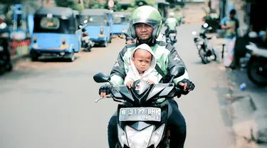 Tajudin harus membawa kedua anaknya saat menarik ojek. Setelah istrinya pergi, Ia harus mengurus anak-anaknya sendiri.