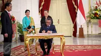 PM Timor Leste Rui Maria De Araujo mengisi buku tamu ditemani Presiden Jokowi di Istana Merdeka, Jakarta, Rabu (26/8). Keduanya melakukan pertemuan bilateral untuk meningkatkan kerjasama Indonesia dan Timor Leste. (Liputan6.com/Faizal Fanani)