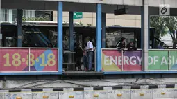 Penumpang menunggu bus Transjakarta di Jalan MH Thamrin, Jakarta, Senin (24/7). Pemprov DKI Jakarta menyiapkan 350 unit bus gratis dengan jumlah 13 ribu penumpang untuk menyambut Asian Games 2018. (Liputan6.com/Faizal Fanani)