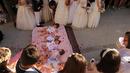 Bayi-bayi berusia hingga satu tahun ditaburi kelopak mawar sambil terlentang di atas matras usai dilompati pria berkostum setan selama festival melompati bayi (El Colacho) di desa Castrillo de Murcia, Spanyol, Minggu (18/6). (CESAR MANSO/AFP)