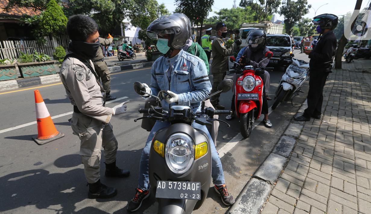 Petugas memeriksa identitas pengendara bermotor pada hari pertama PSBB di jalur check point Jalan Ir. H Juanda, Ciputat, Tangerang Selatan, Sabtu (18/4/2020). Selama PSBB pengendara motor wajib kenakan master dan tidak boleh berboncengan kecuali suami istri. (Liputan6.com/Fery Pradolo)