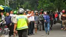 Seorang polisi berusaha membubarkan aksi lempar batu antara sopir taksi yang melakukan unjuk rasa dengan pengemudi ojek online, di kawasan Sudirman, Jakarta, Selasa (22/3). (Liputan6.com/Faisal R Syam)